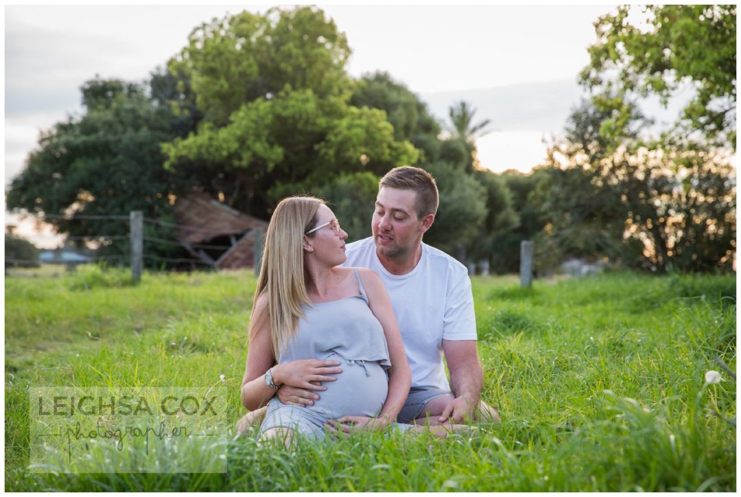 couple snuggle green grass